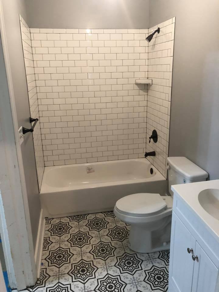 A bathroom with a bathtub , toilet , sink and shower.