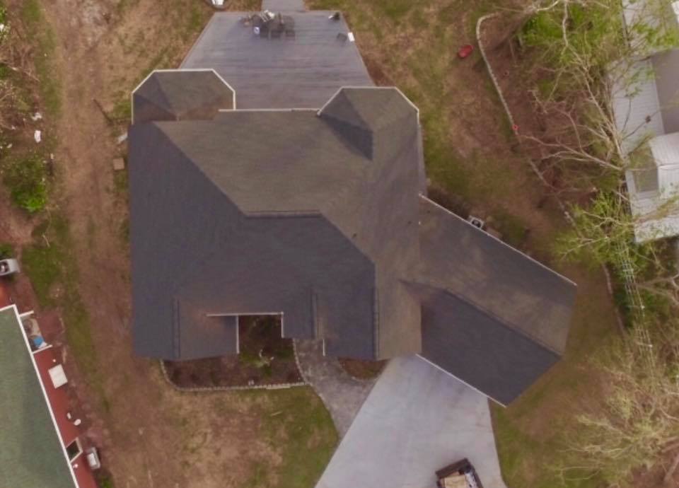 An aerial view of a house with a black roof