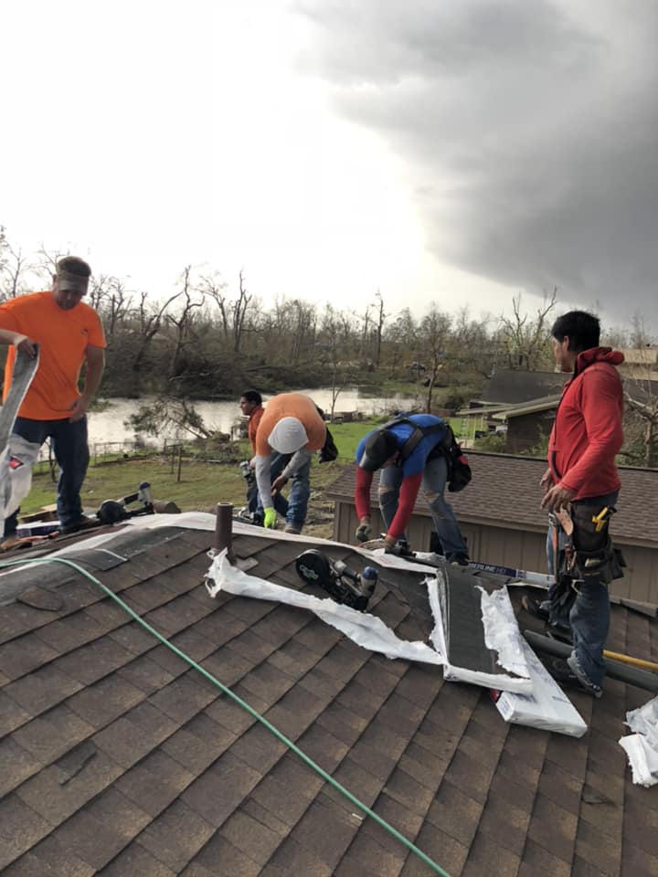 A group of men are working on a roof.