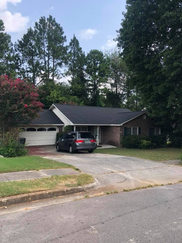 A car is parked in front of a brick house