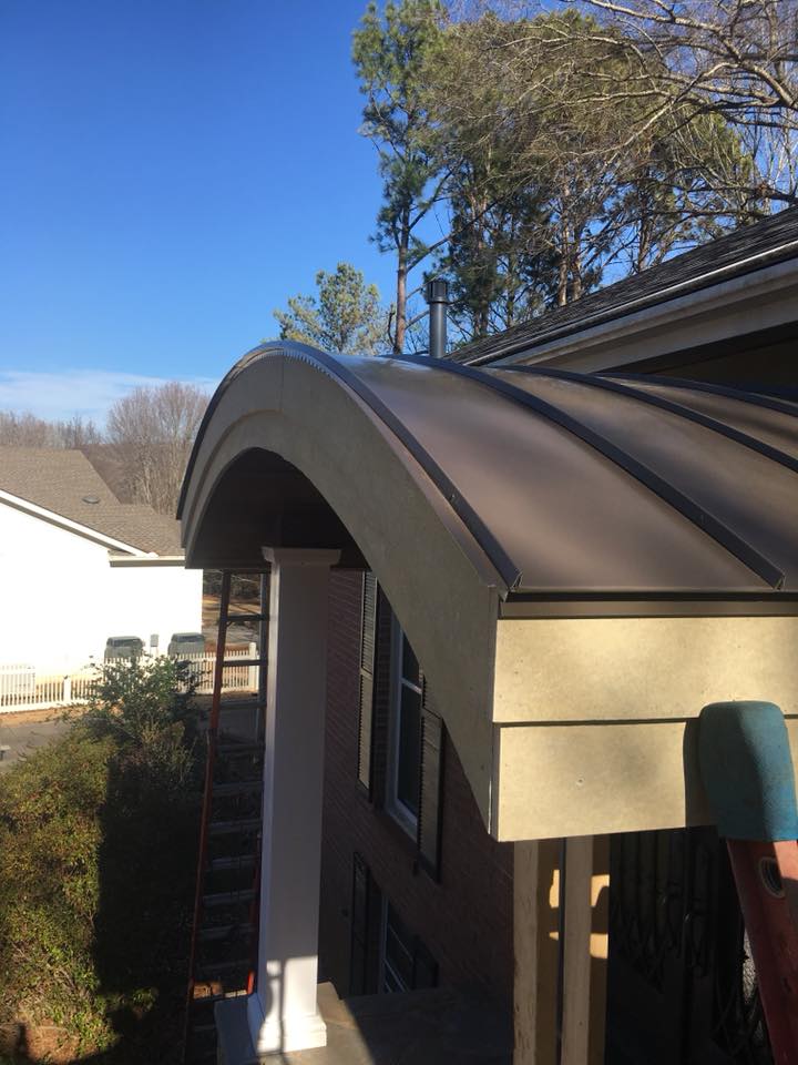 A house with a curved roof and a ladder on the side