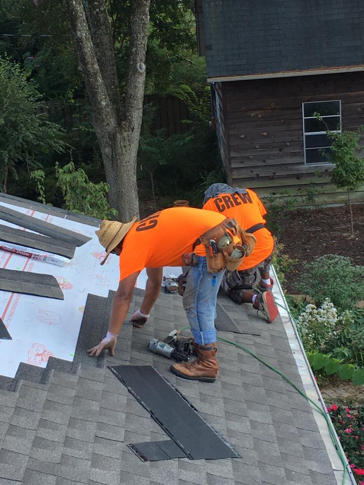 A group of men are working on a roof.