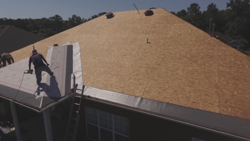 A man is working on the roof of a house.