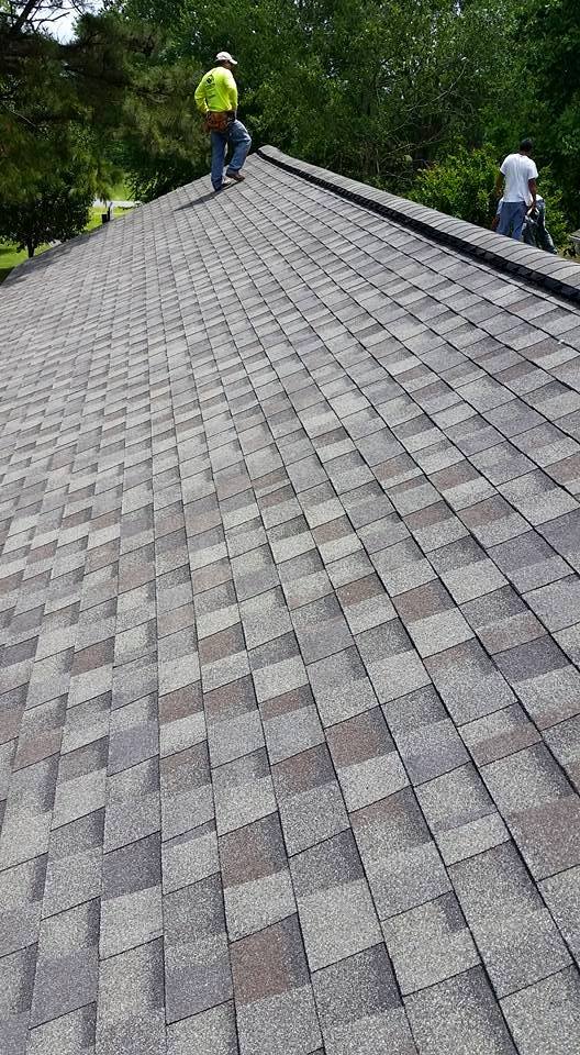 A man is standing on top of a roof.