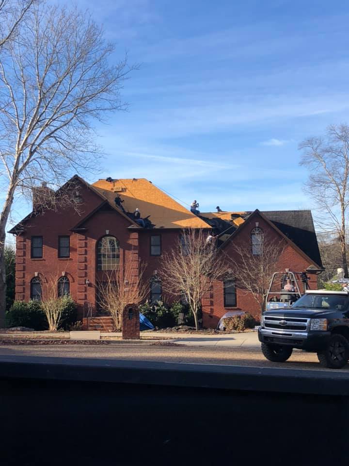 A large brick house with a truck parked in front of it.