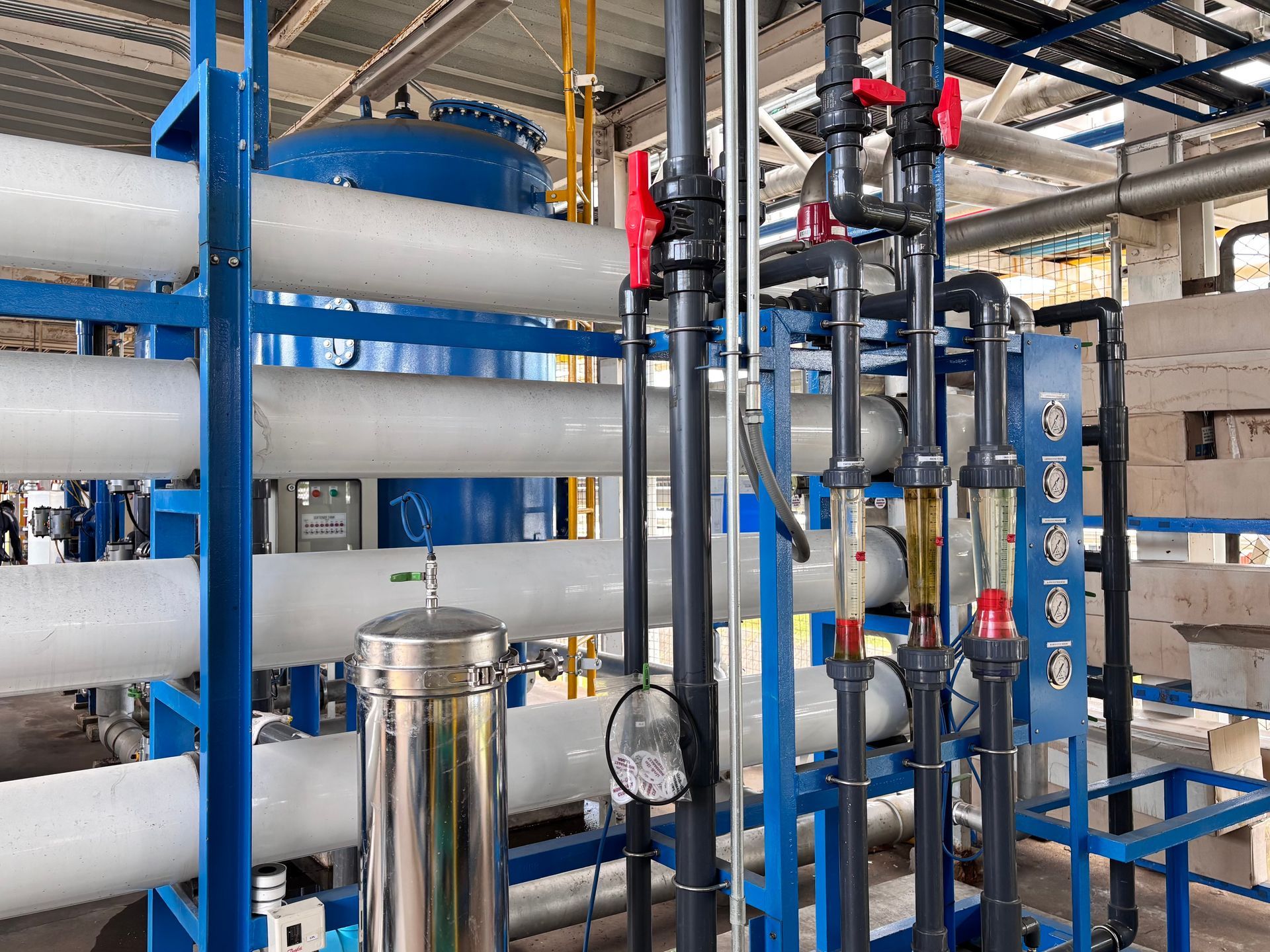 A large industrial reverse osmosis water treatment system with pressure vessels, pipes, and gauges.