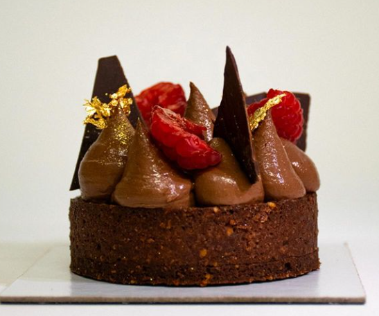 una torta al cioccolato con fragole e cioccolato su un piatto bianco .