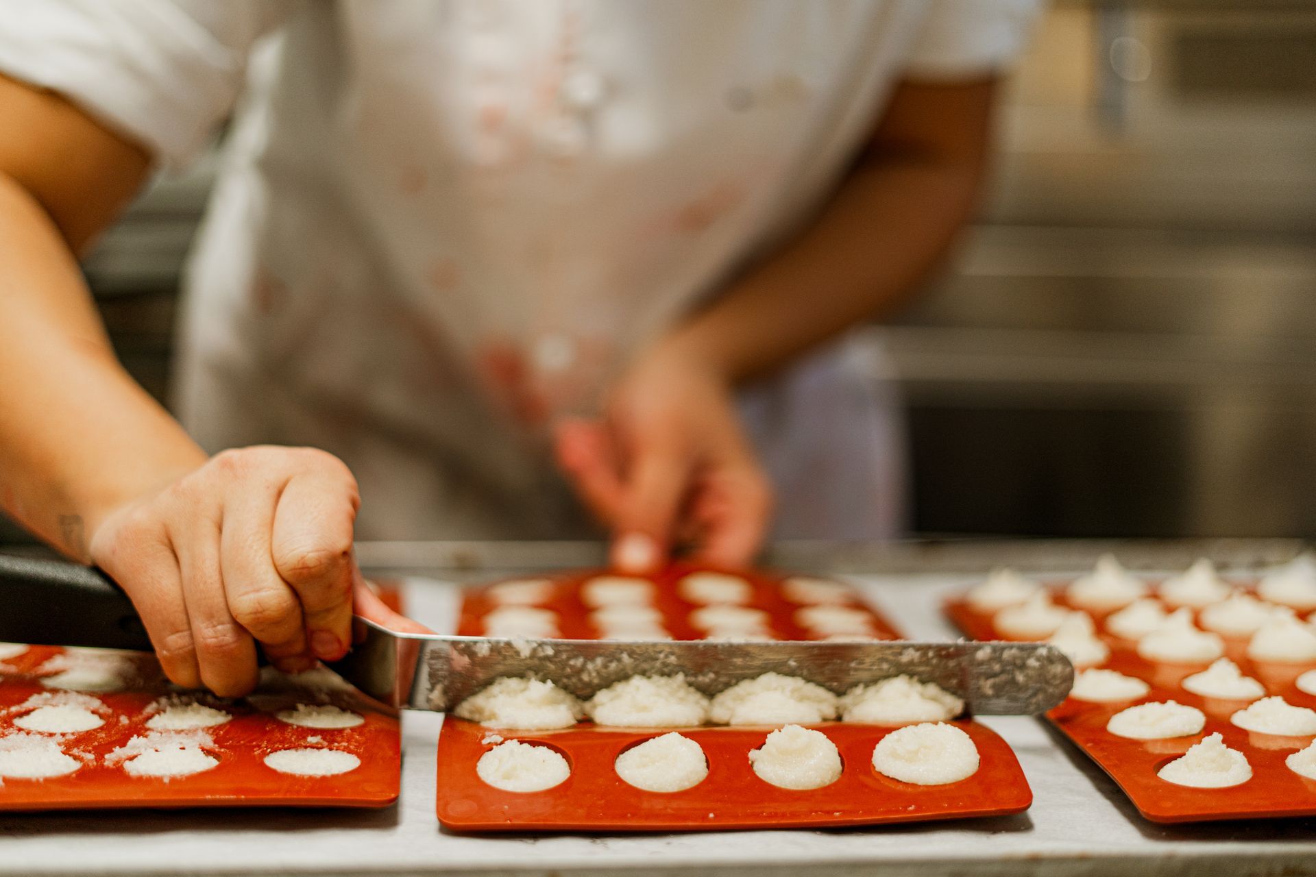 una persona sta tagliando i biscotti su un vassoio di silicone in una cucina .