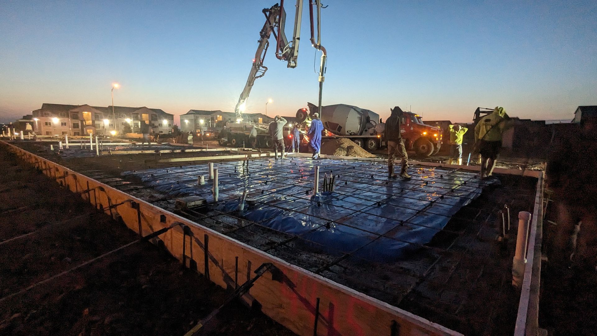 An aerial view of a construction site with a crane in the middle.
