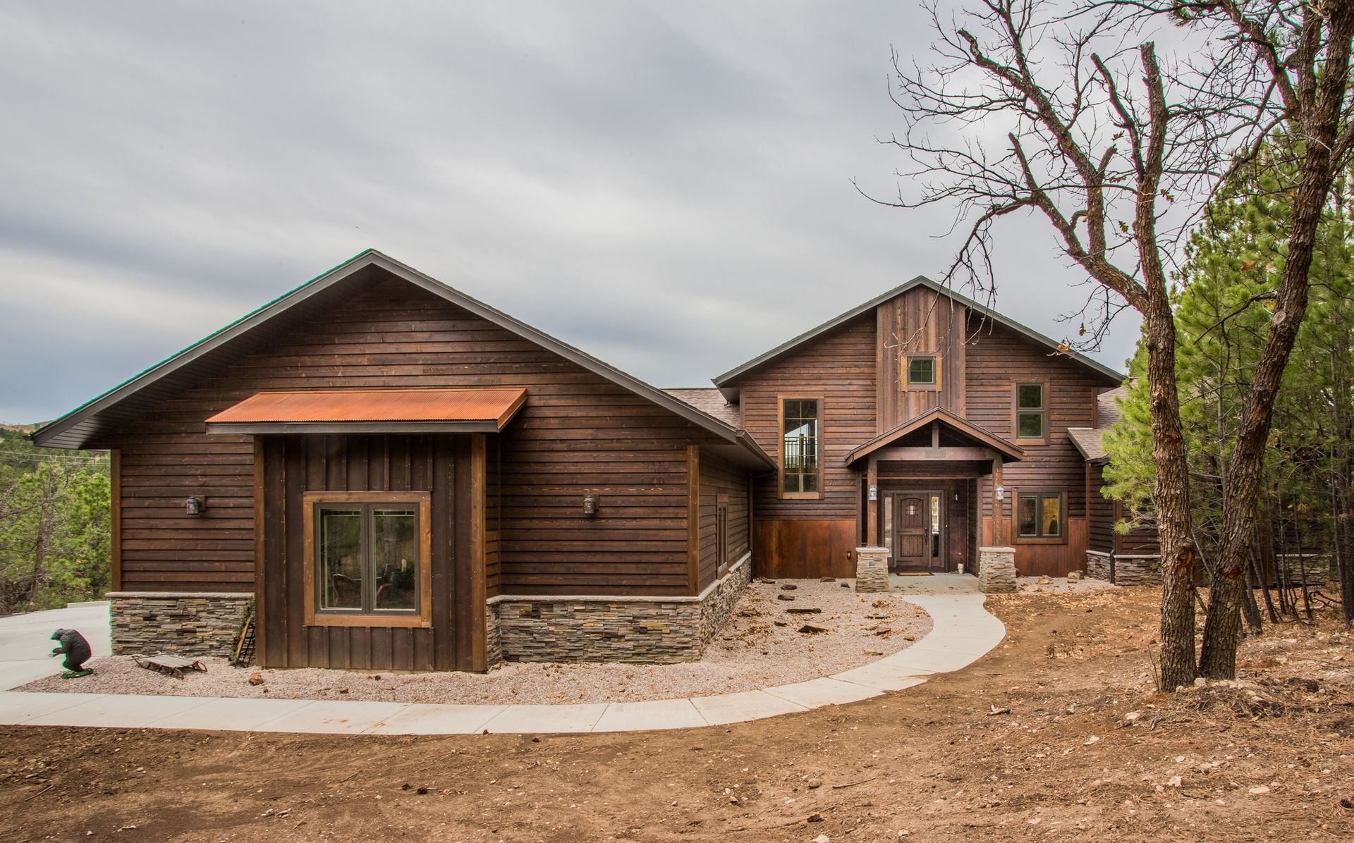 A large white house with a black roof is sitting on top of a lush green lawn.