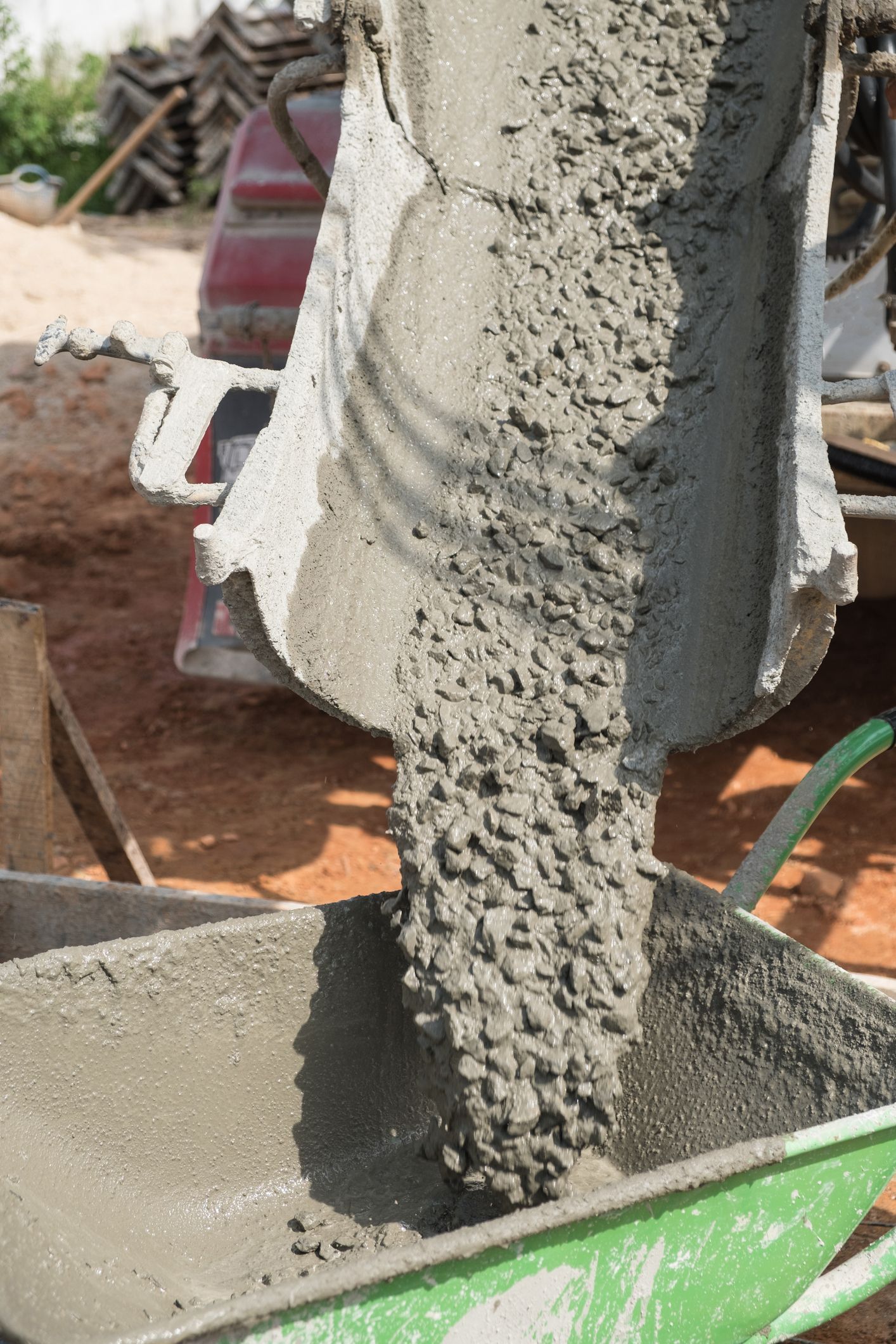 Close-up of concrete mix being poured into a container from a cement mixer. Close-up of concrete mix being poured into a container from a cement mixer.