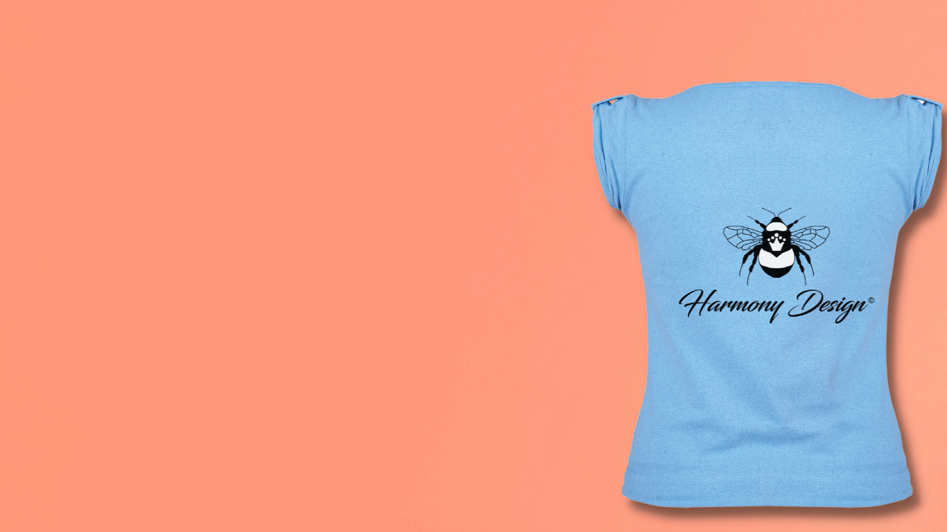 A light blue heat press t-shirt with the Harmony Design bee logo