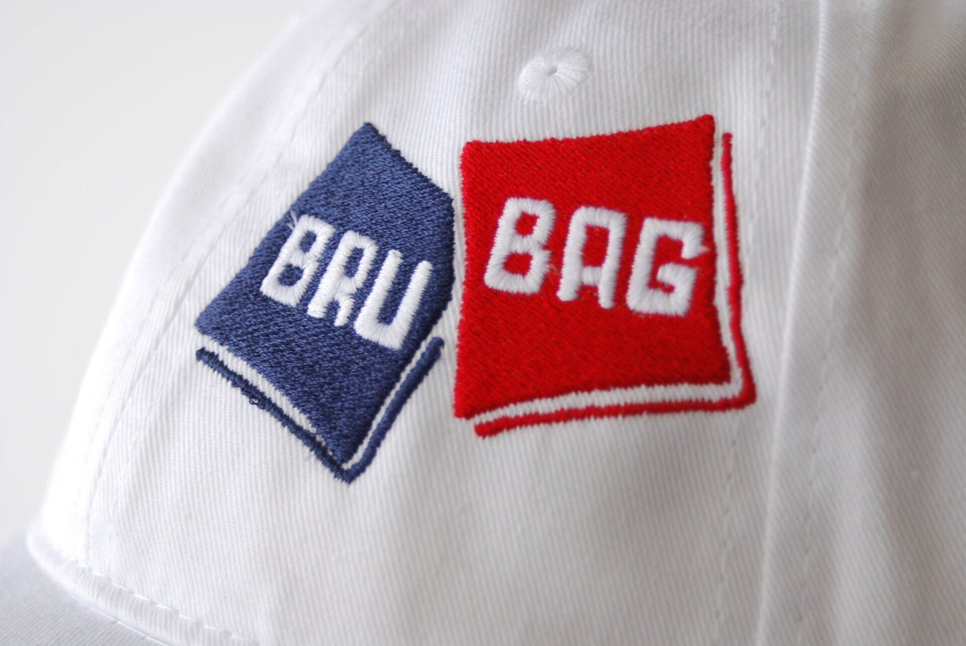 A white hat with the Bru Bag logo on it