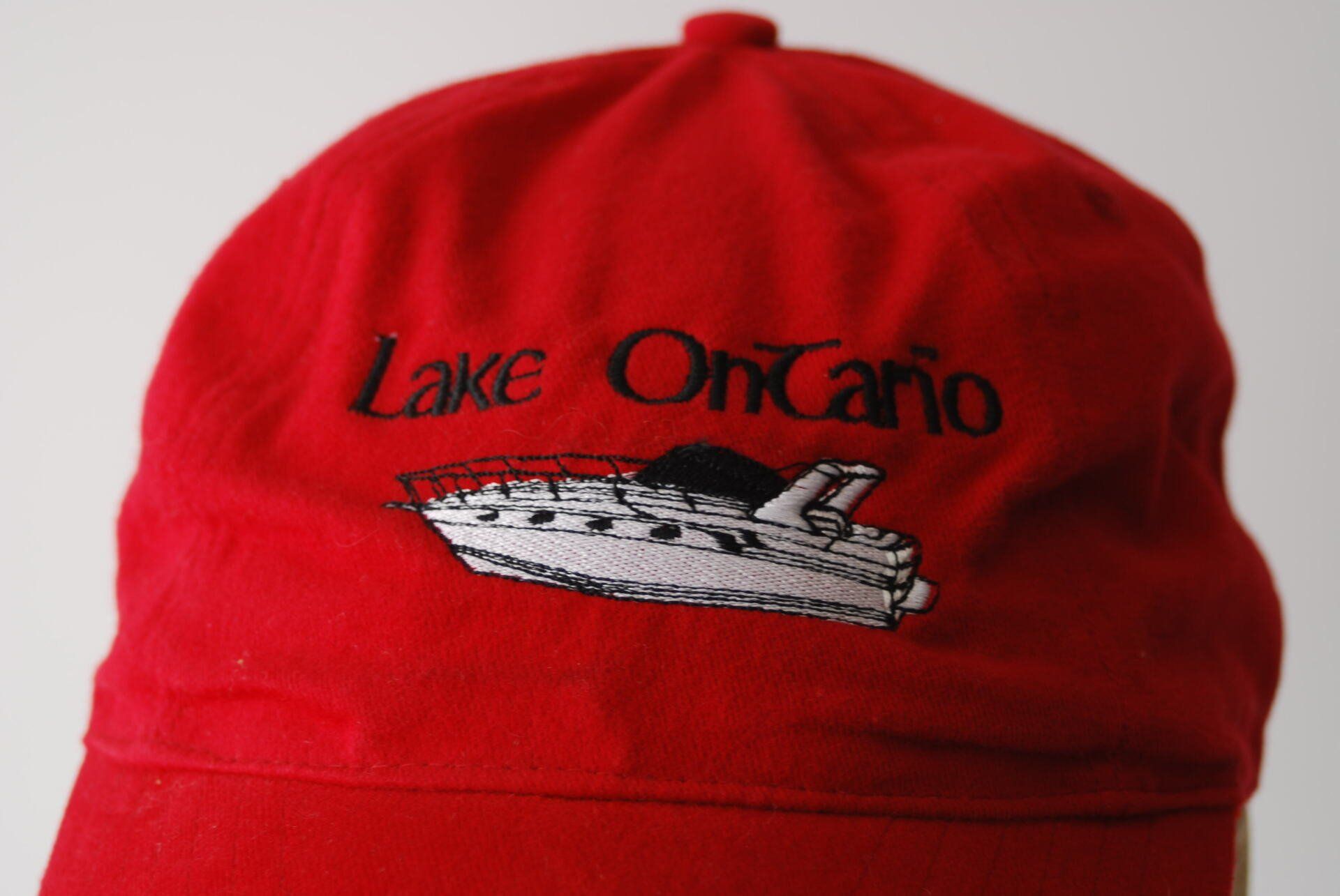 A red hat with a Lake Ontario boat embroidered on it