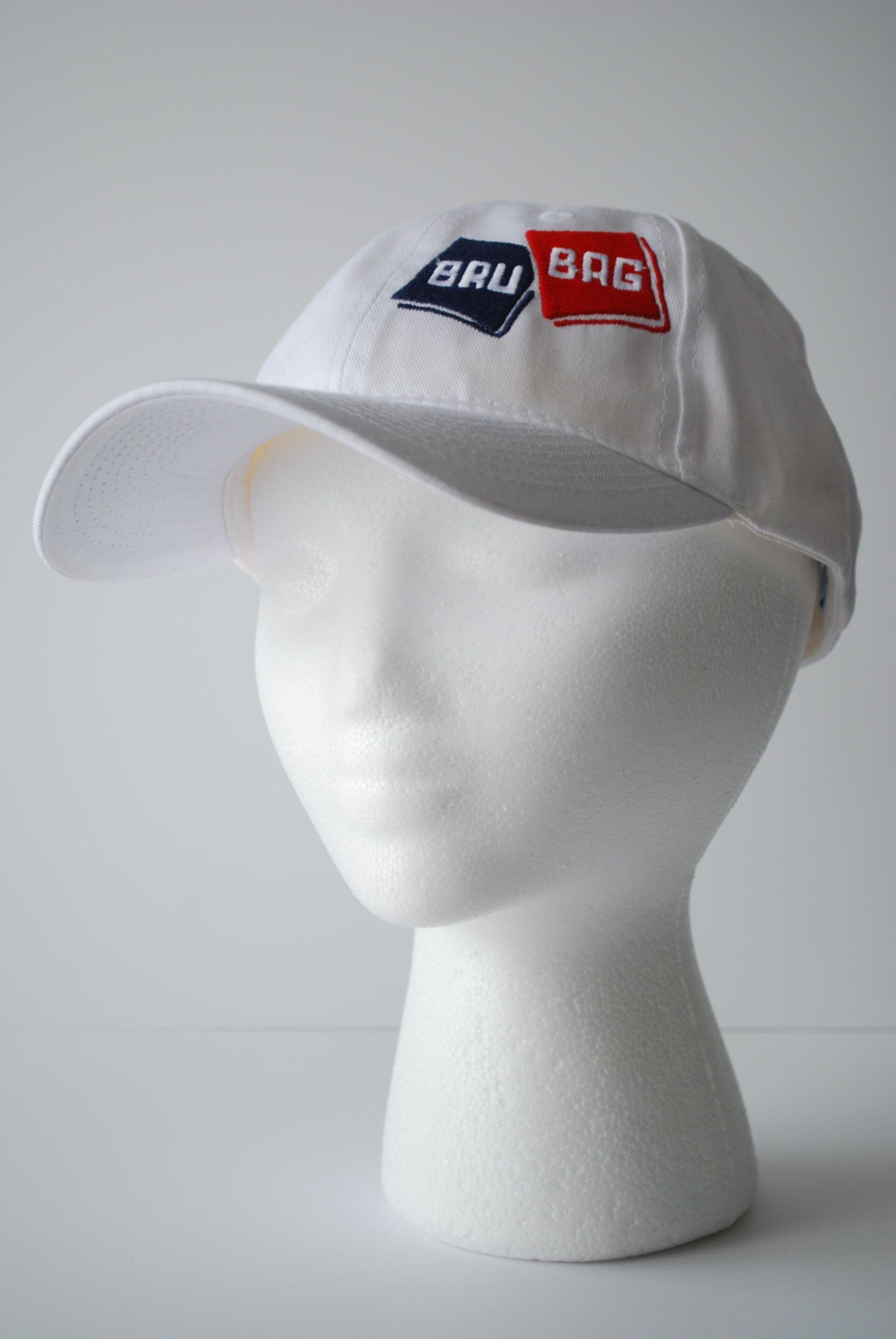 A white baseball cap with Bru Bag's logo embroidered on it