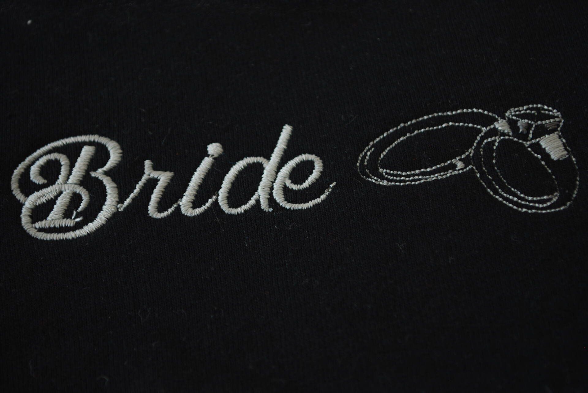 The word Bride embroidered on black apparel