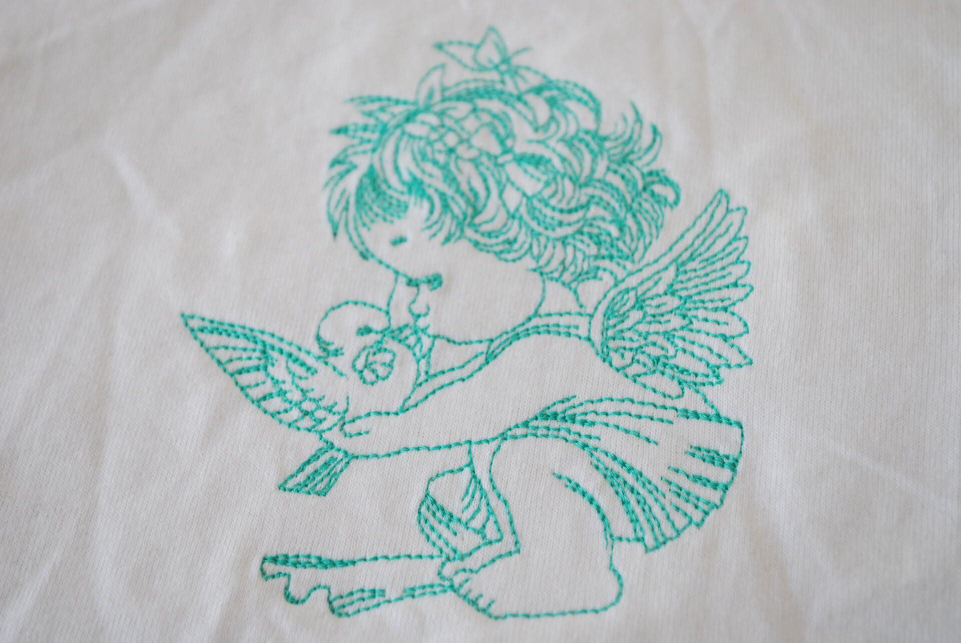 A little cherub embroidered on white