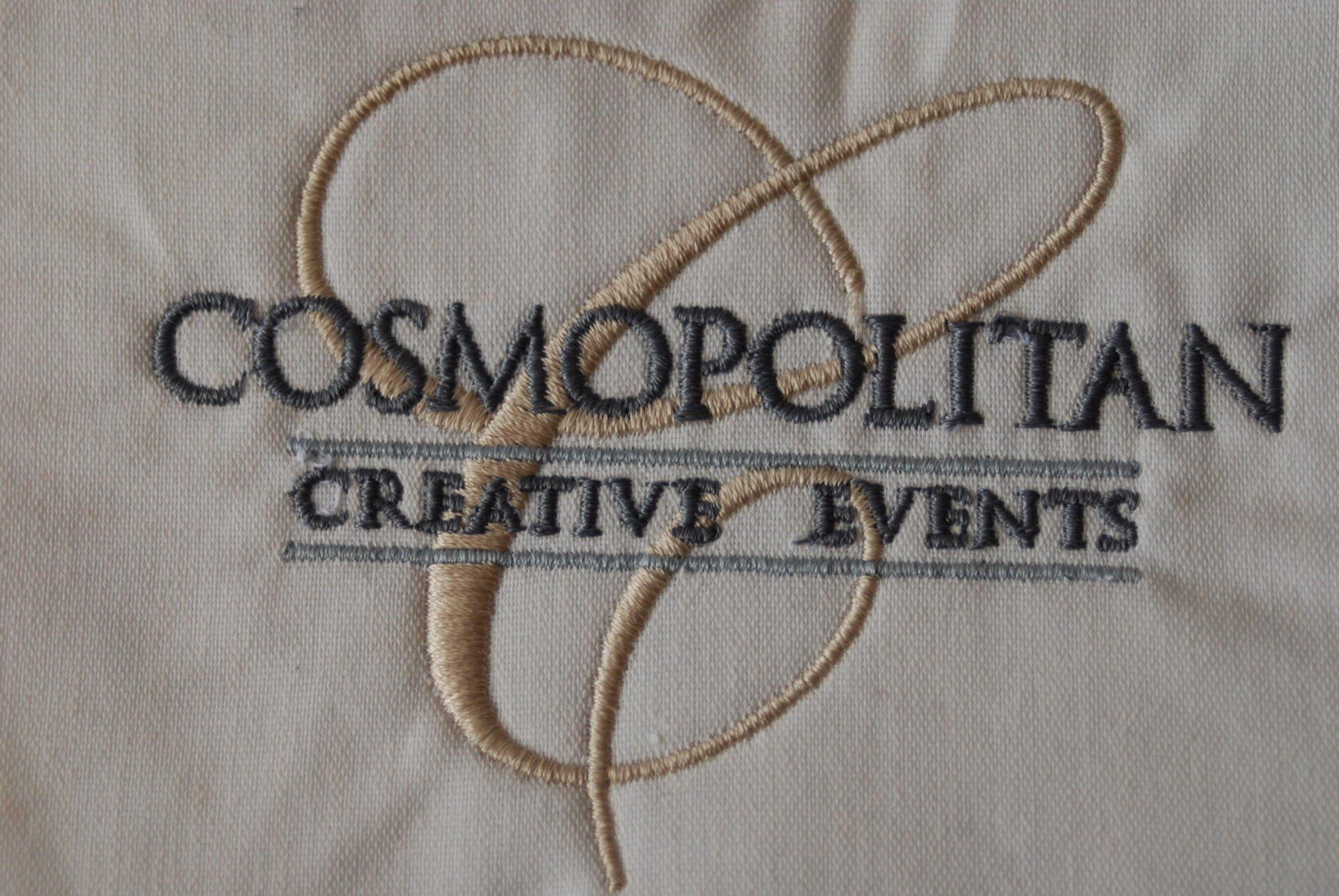 A close up of the Cosmopolitan Creative Events logo embroidered on white