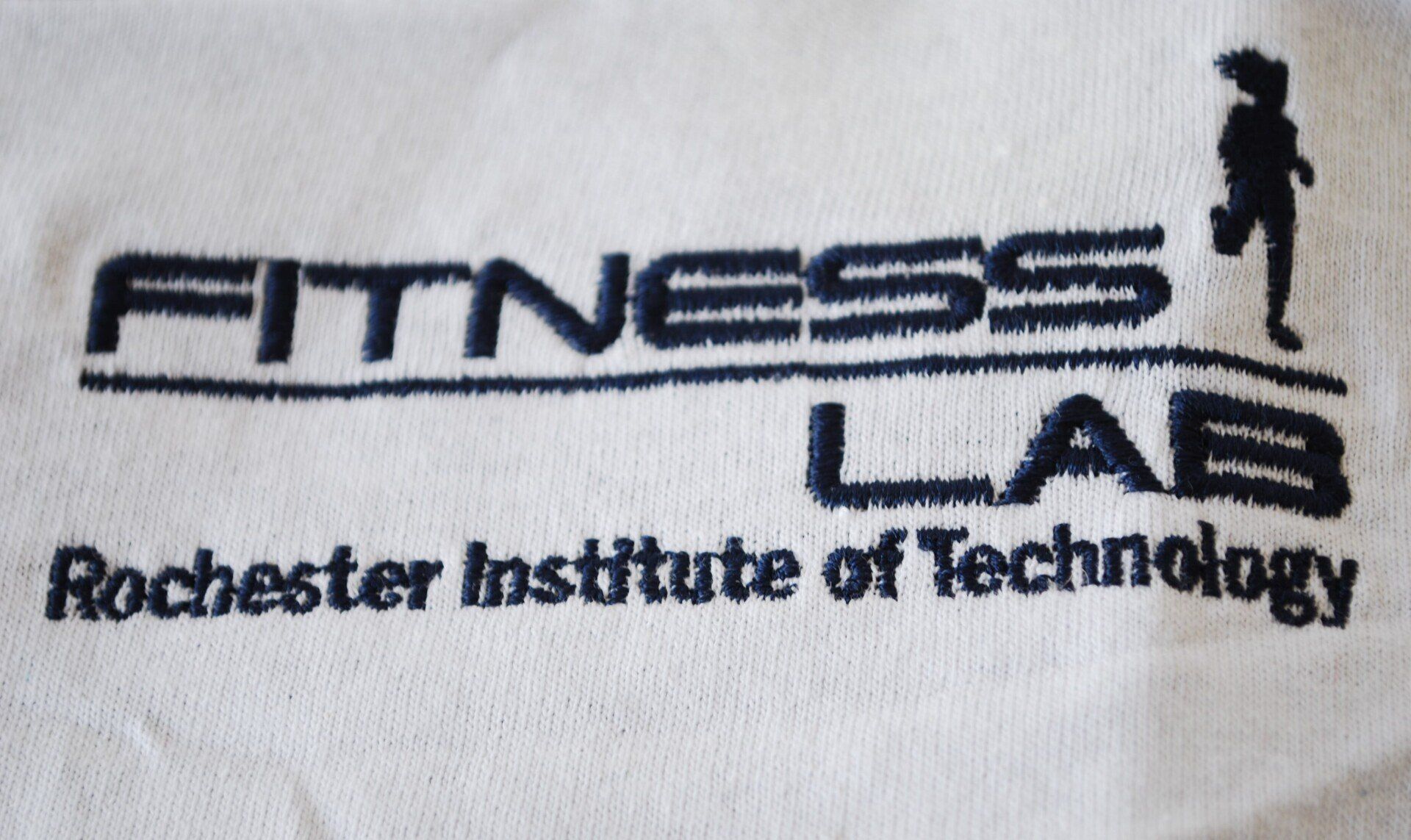 A white shirt with the Fitness Lab's logo embroidered on it