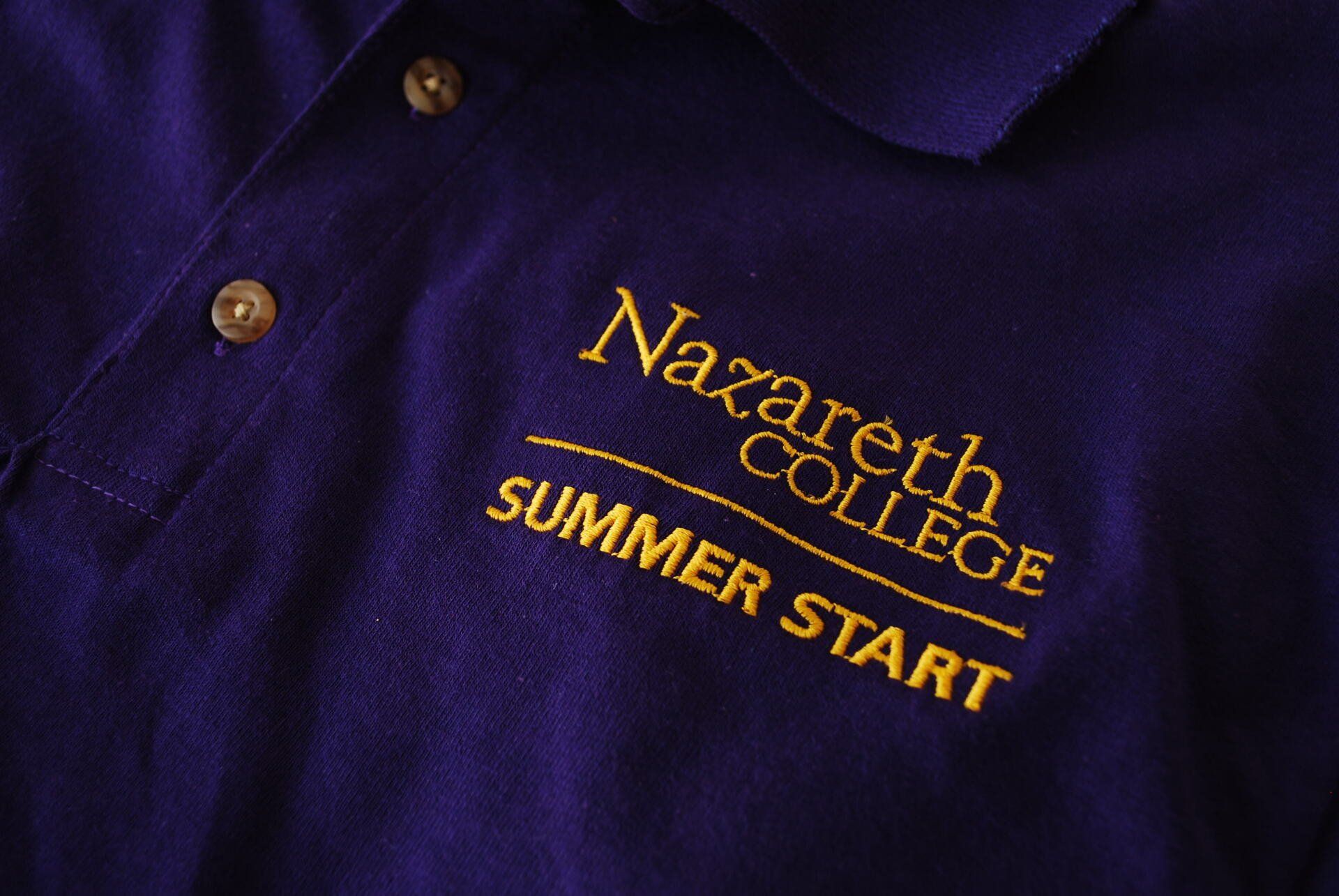 A purple shirt with Nazareth College Summer Start embroidered on it