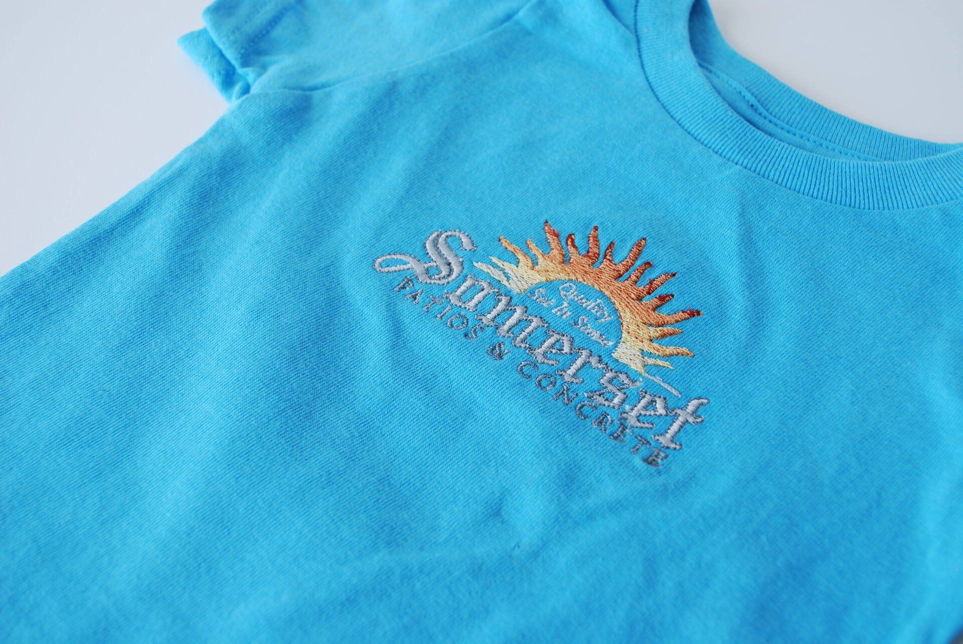 A blue shirt with the Somerset logo embroidered on it