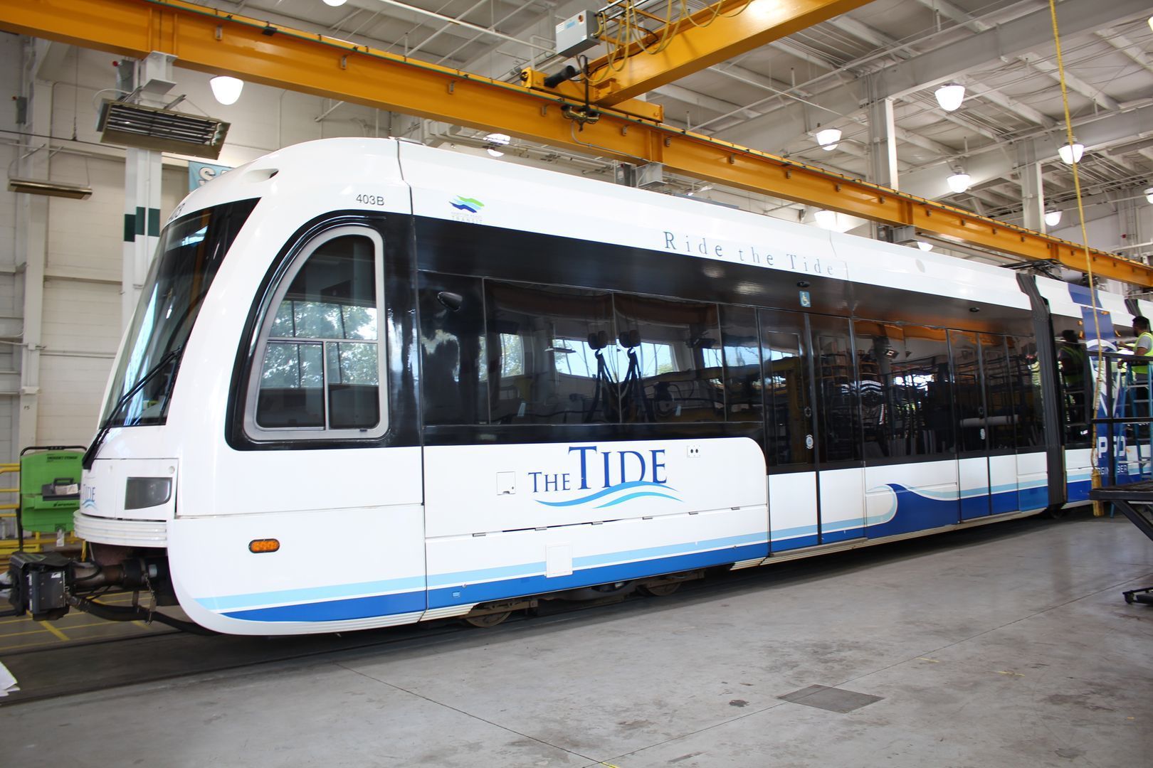 A white and blue light rail train car, 