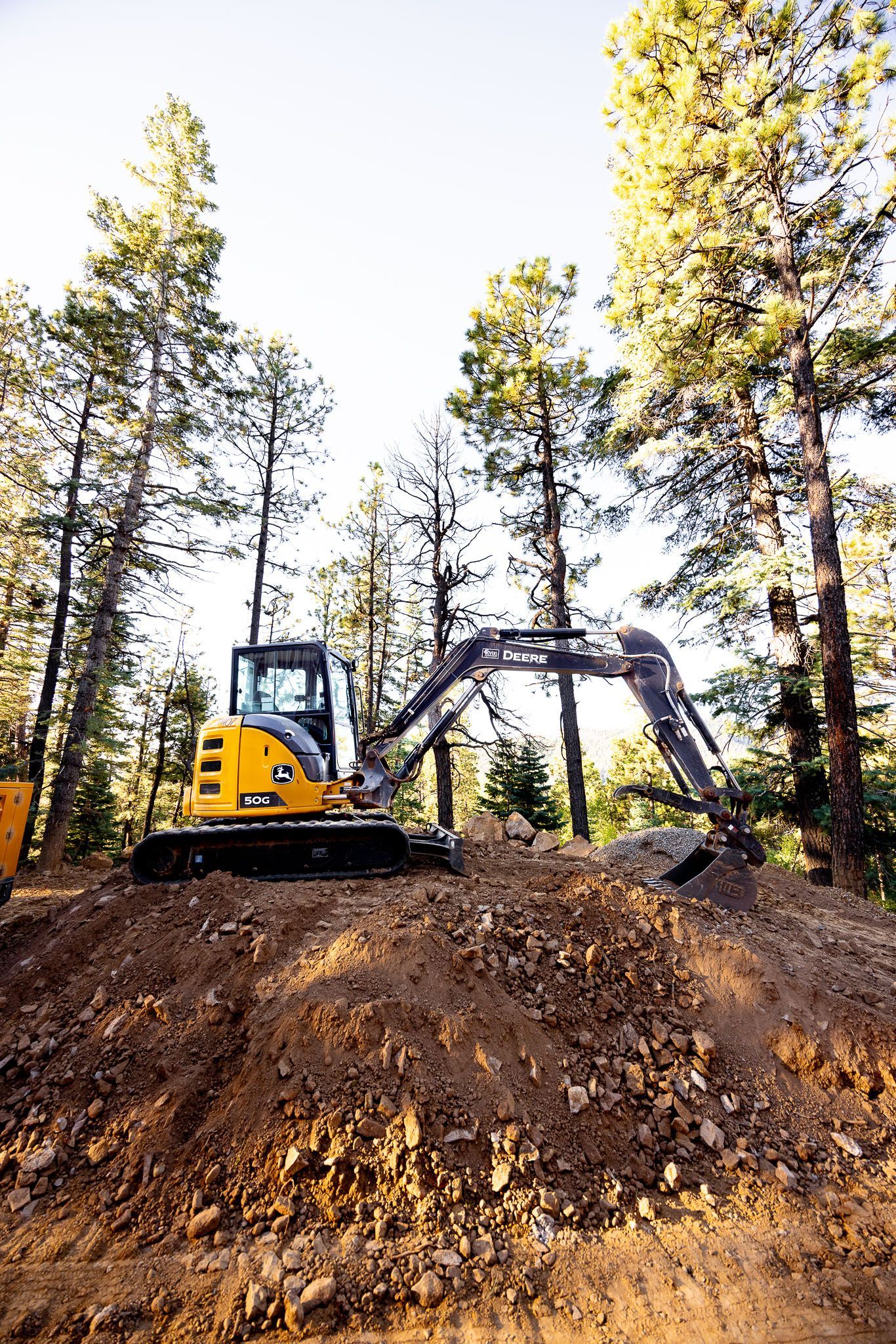 Yellow excavator demolishing a brick building. 