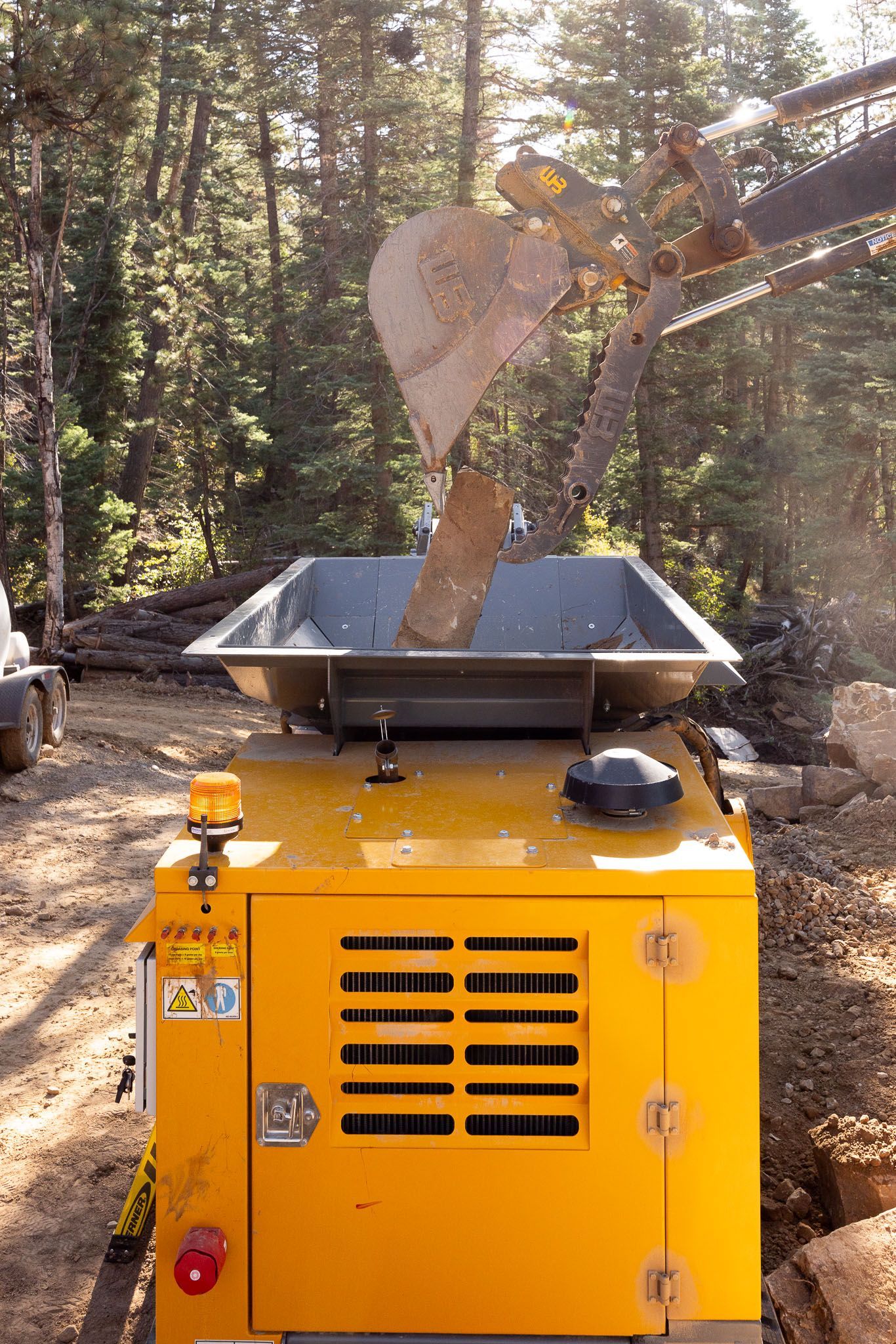 An orange excavator demolishes a multi-story building against a blue sky.