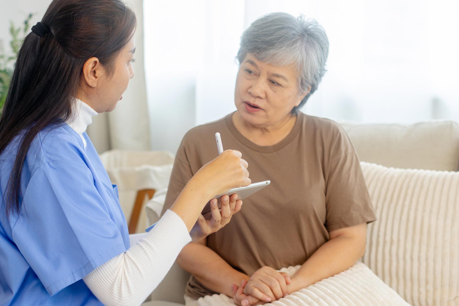 A caregiver is talking to an elderly woman.