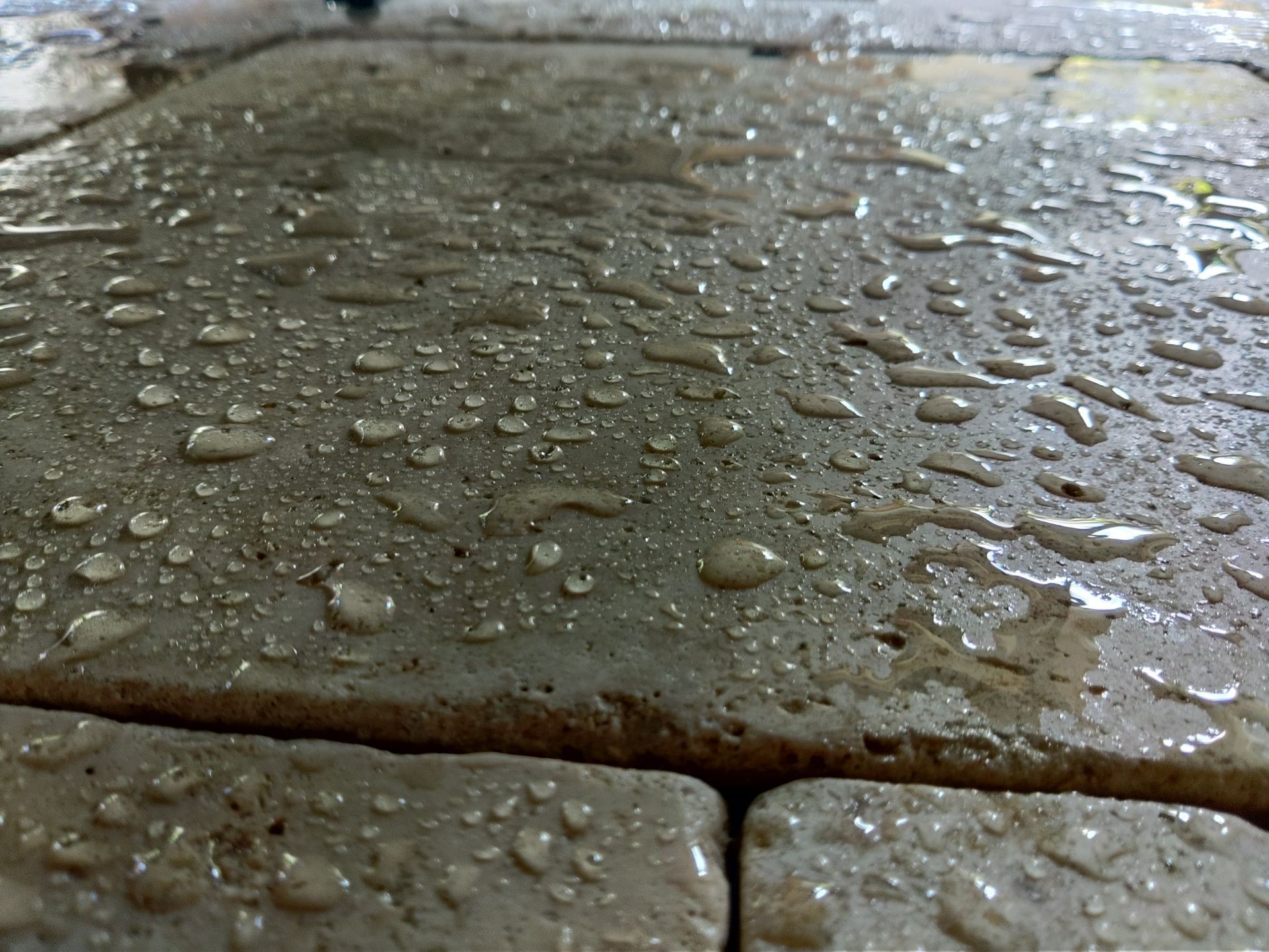 A close up of natural stone patio with water drops on it.