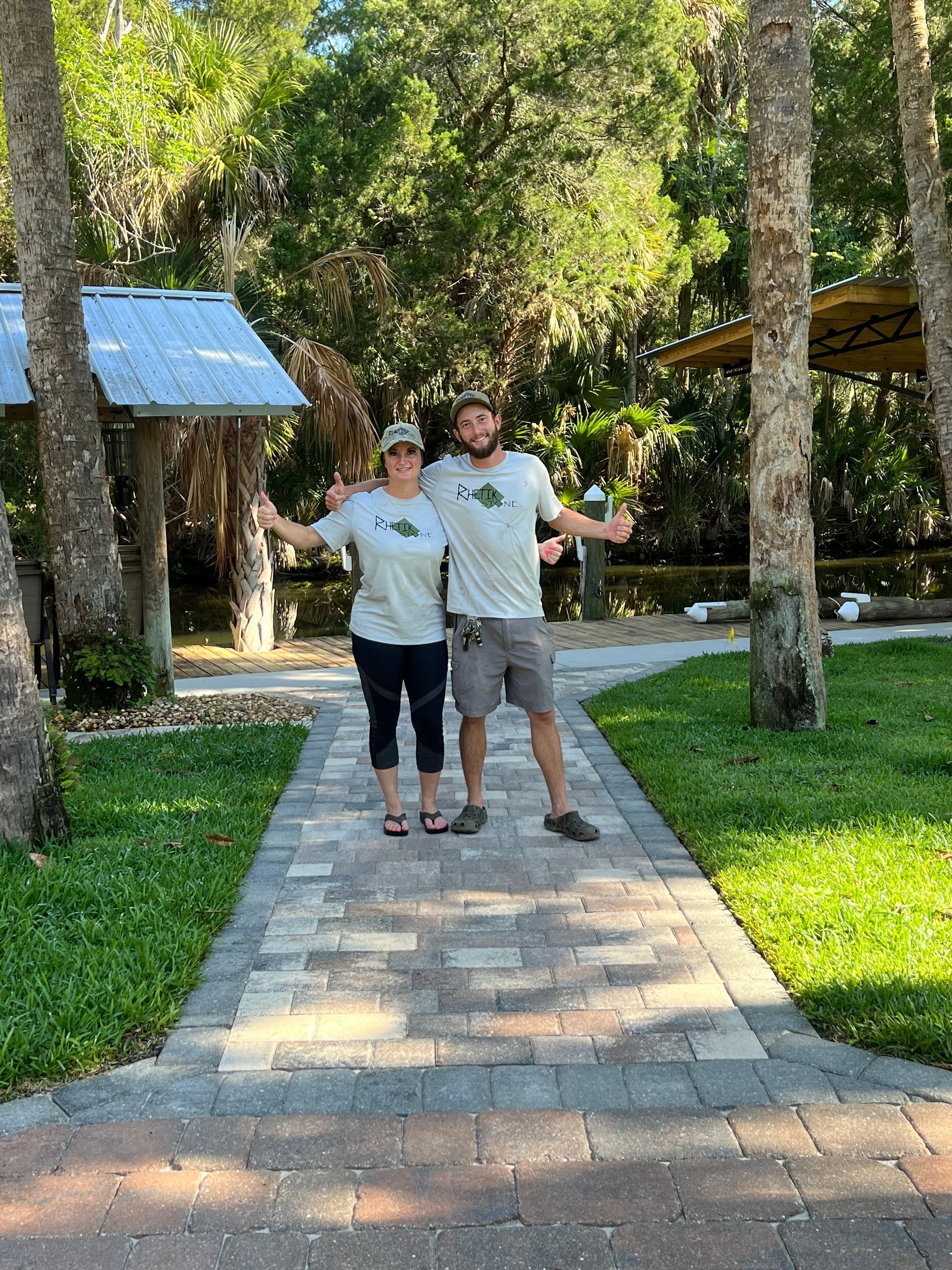 A man and a woman are standing next to each other on a brick walkway.