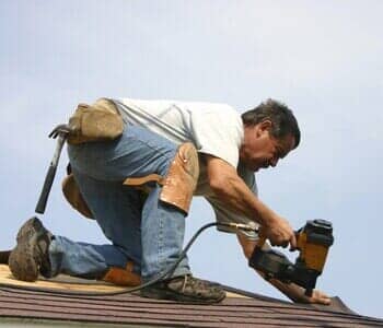 Man putting shingles on roof - tri state in West Congers, NY