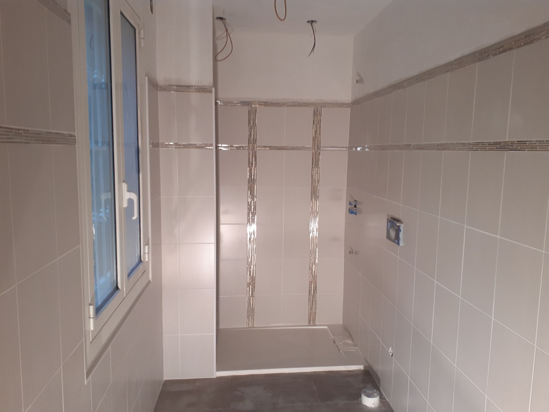 Un bagno con cabina doccia e finestra.