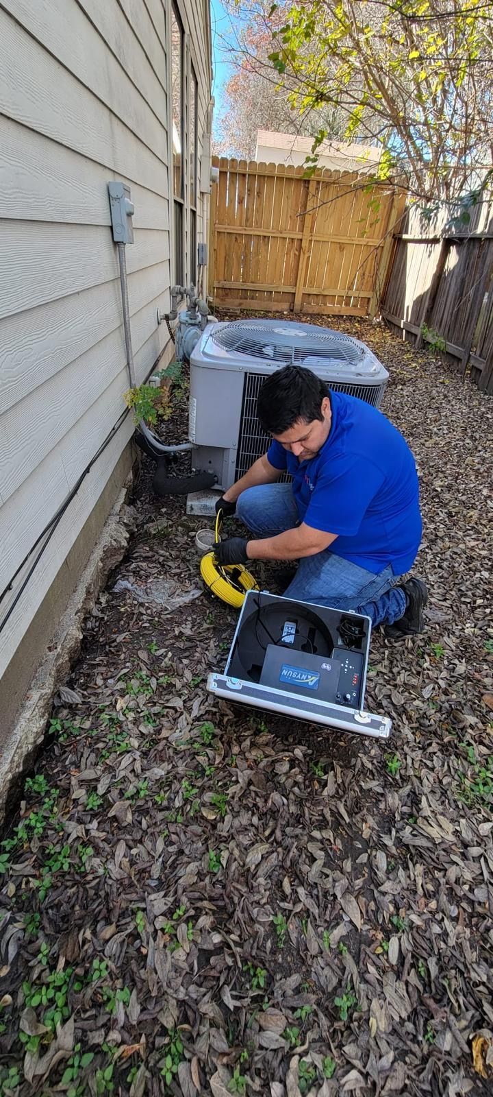 An HVAC repair guy repairing the outdoor AC unit in Katy. 
