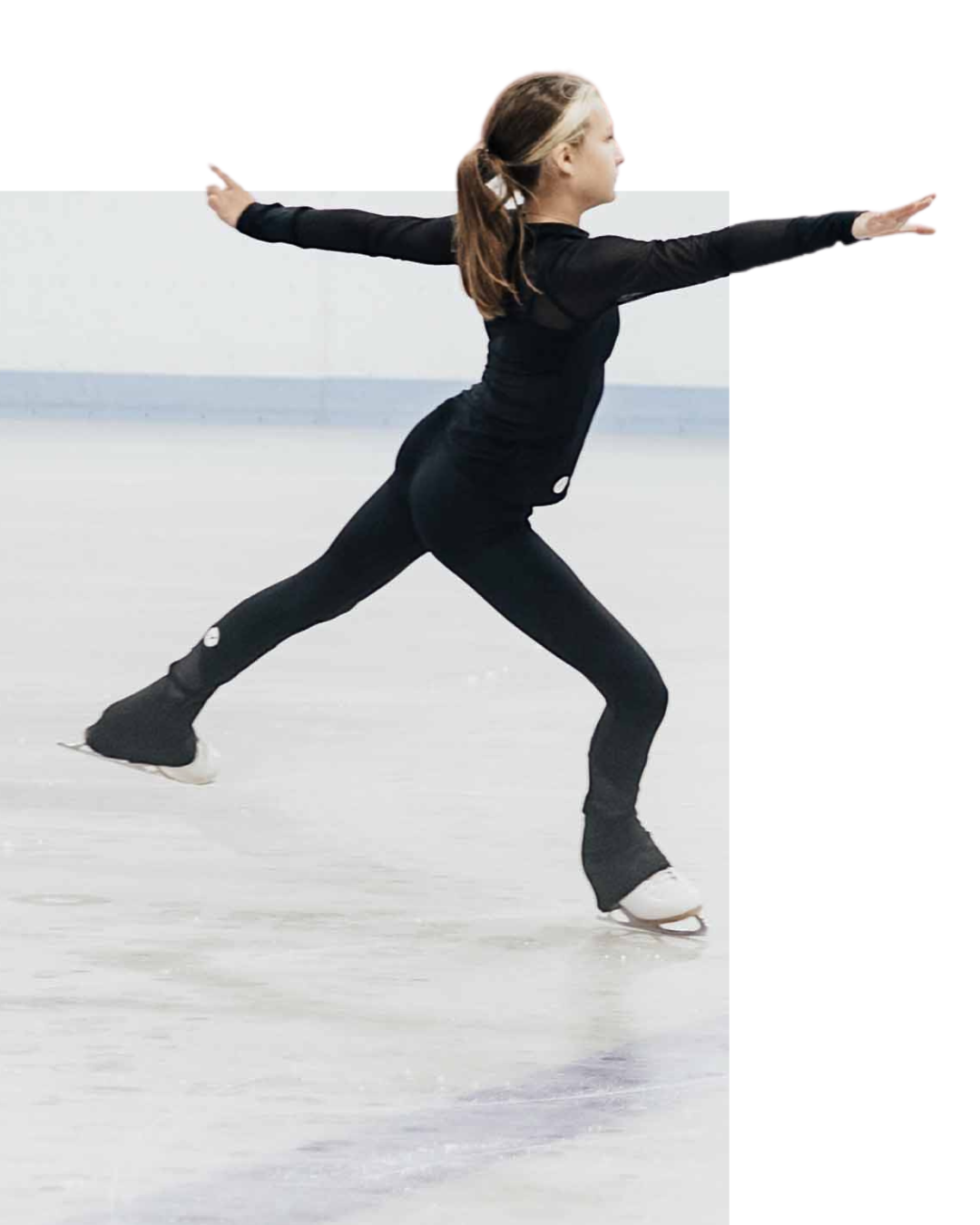 Young ice skater in black outfit performing a spin with arms outstretched.