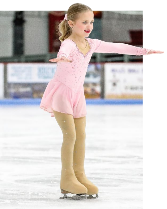 Young figure skater in a pink dress gliding on ice with arms extended