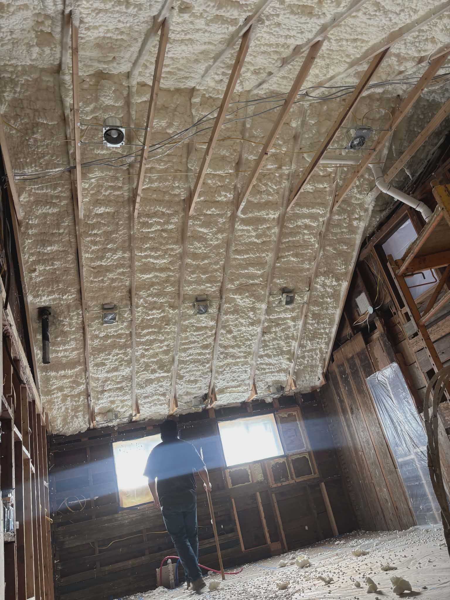 Woman in straw hat smiles, holding wine glass near a lake.