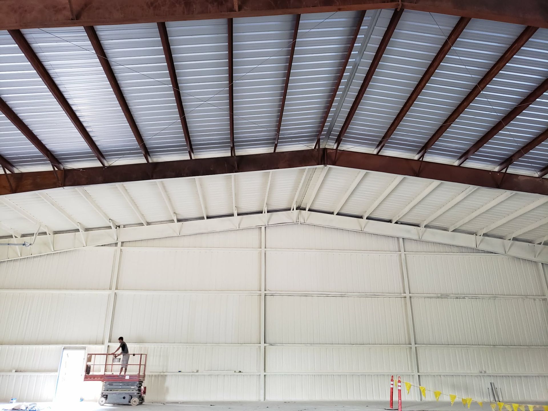 Woman in straw hat smiles, holding wine glass near a lake.