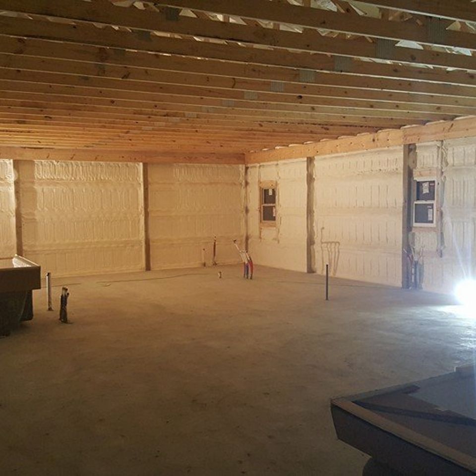 Woman in straw hat smiles, holding wine glass near a lake.