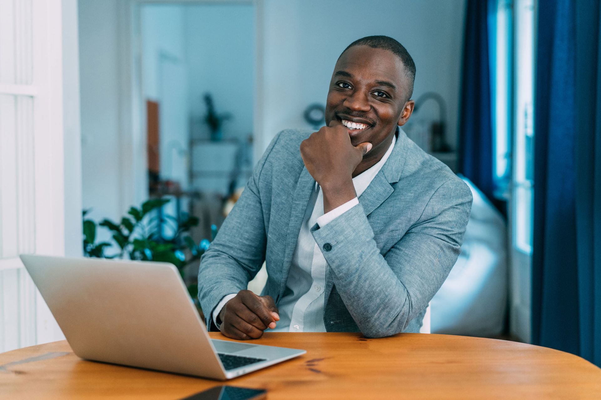 A Man In A Suit Sits At A Table With A Laptop — West Orange, NJ — Omni Management Corp