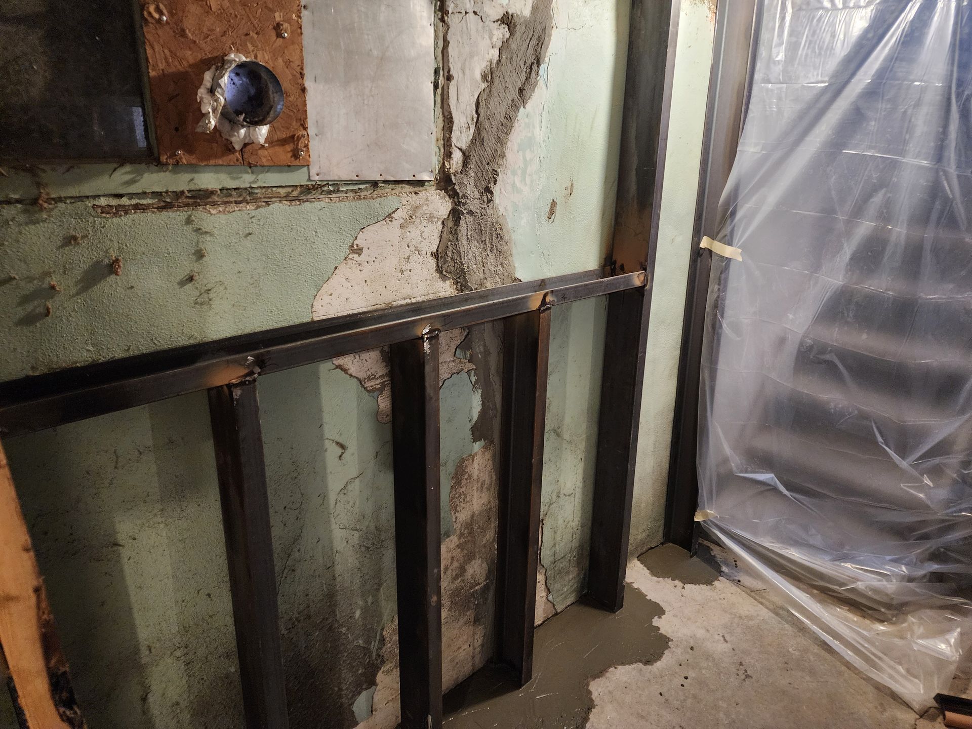 Metal framing against a cracked basement wall