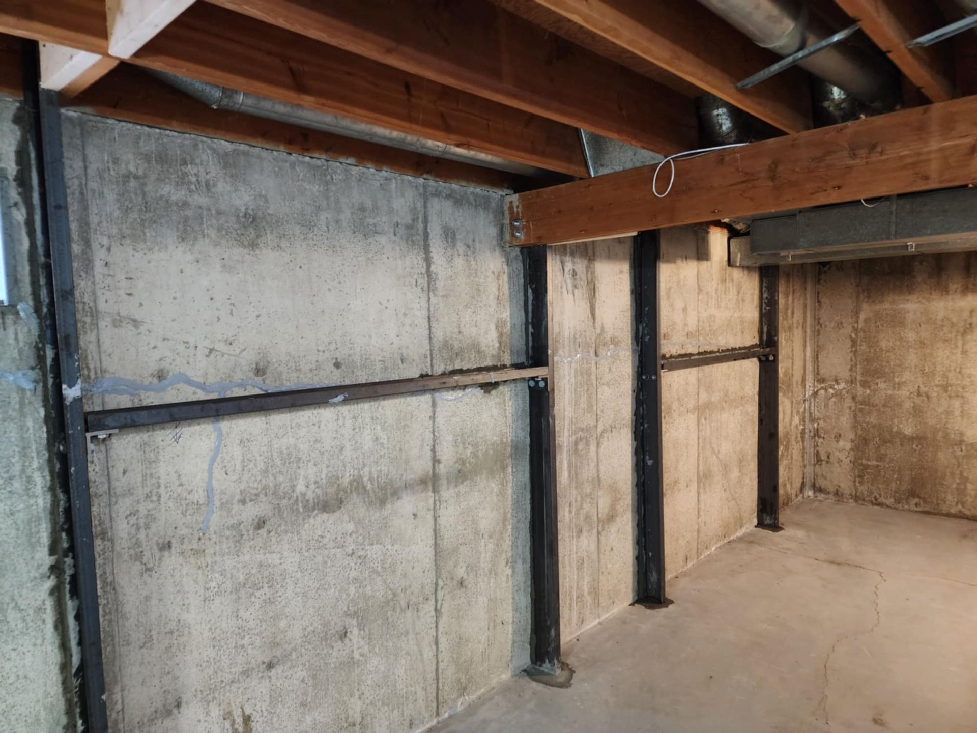 Concrete basement walls reinforced with  steel beams and supports.