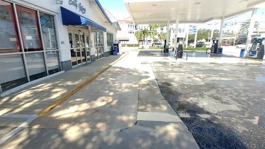 A gas station with a canopy over it and a sidewalk in front of it.