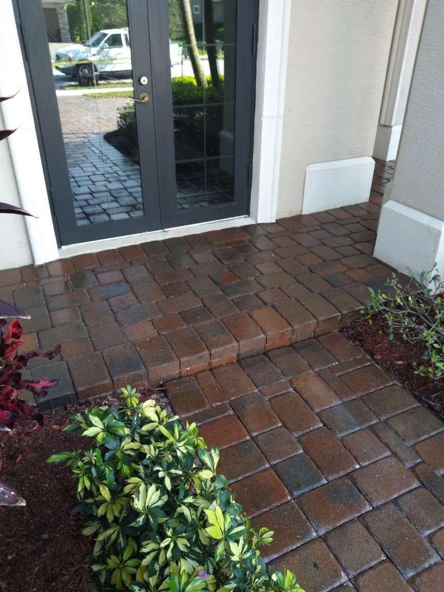A brick walkway leading to the front door of a house.