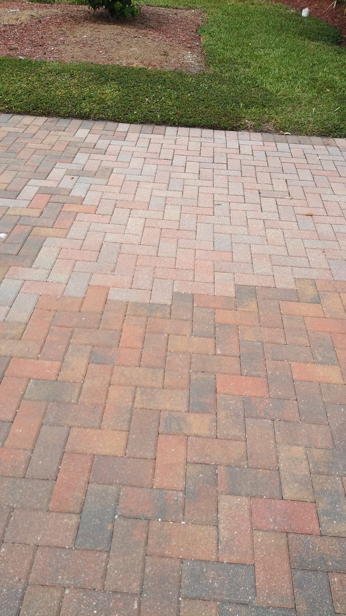 A brick walkway with a grassy area in the background.