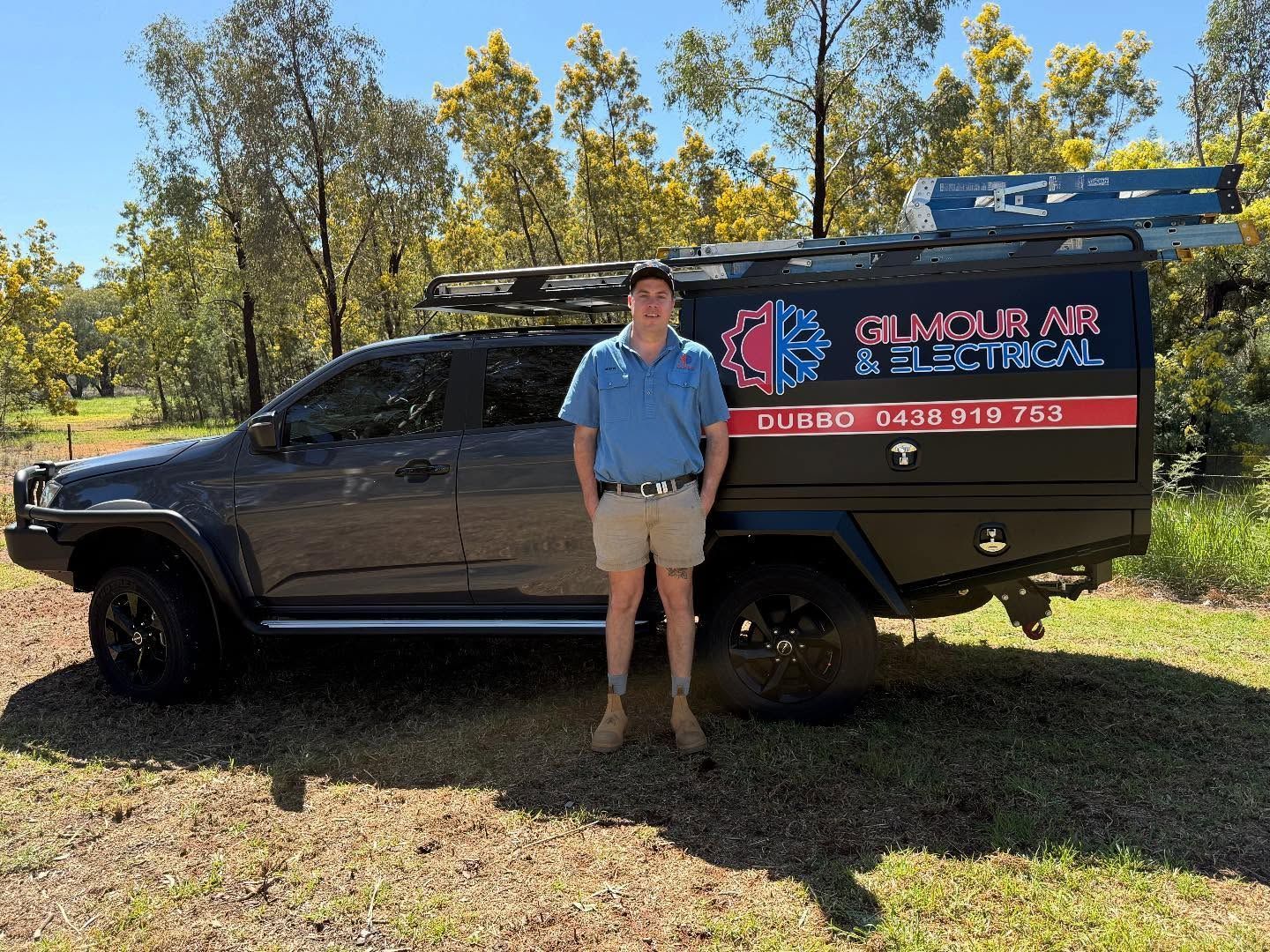 Man Standing Next to A Work Truck with Gilmour Air & Electrical Signage — Gilmour Air & Electrical in Dubbo, NSW