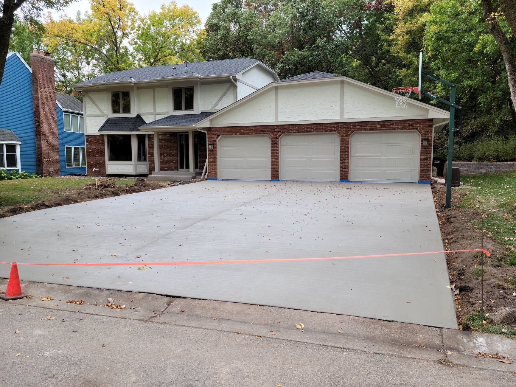 A brick house with a concrete driveway in front of it
