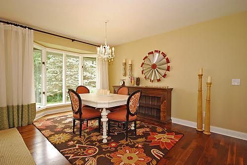 A dining room with a table and chairs and a rug.