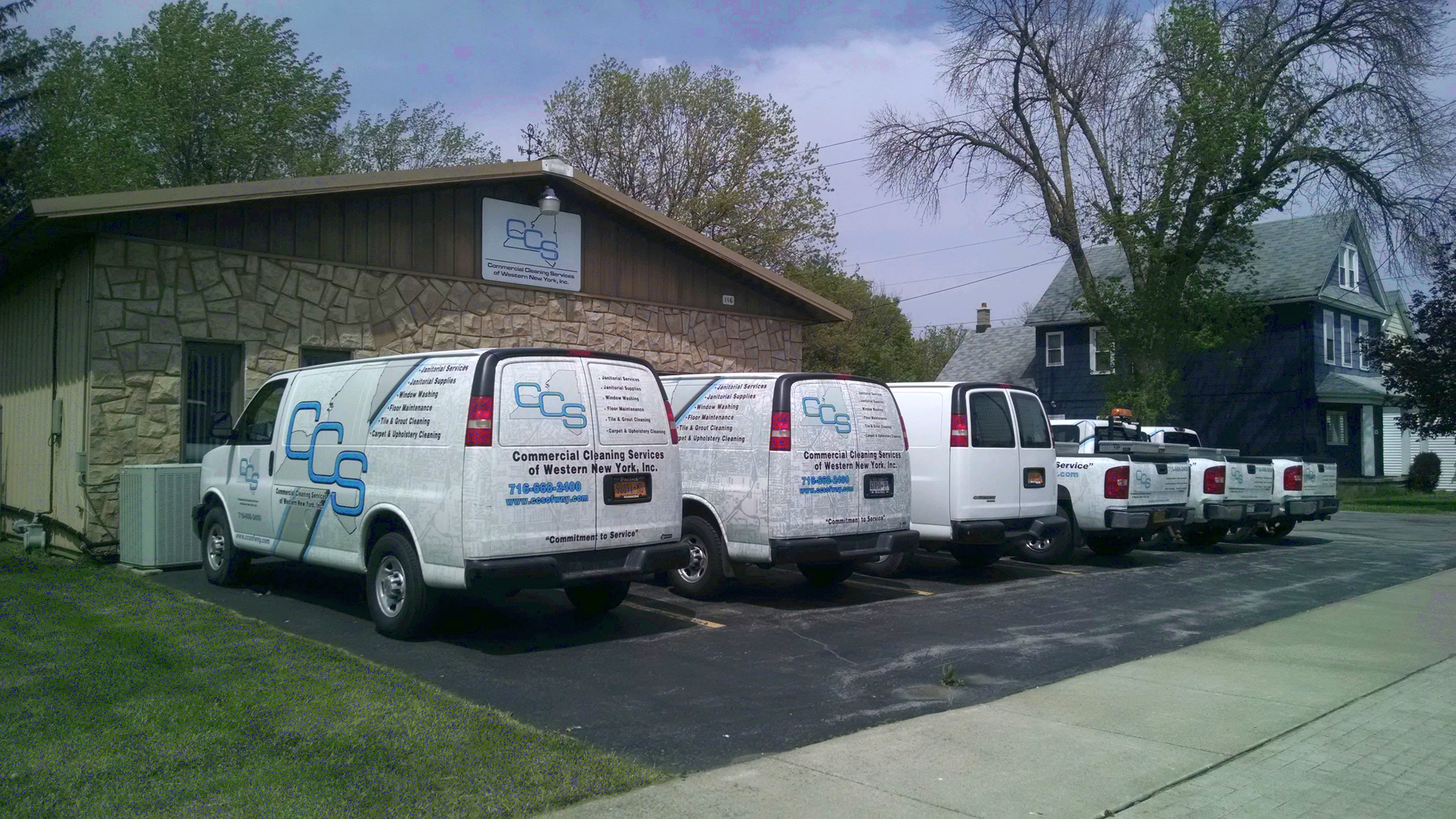A row of white vans parked in front of a building