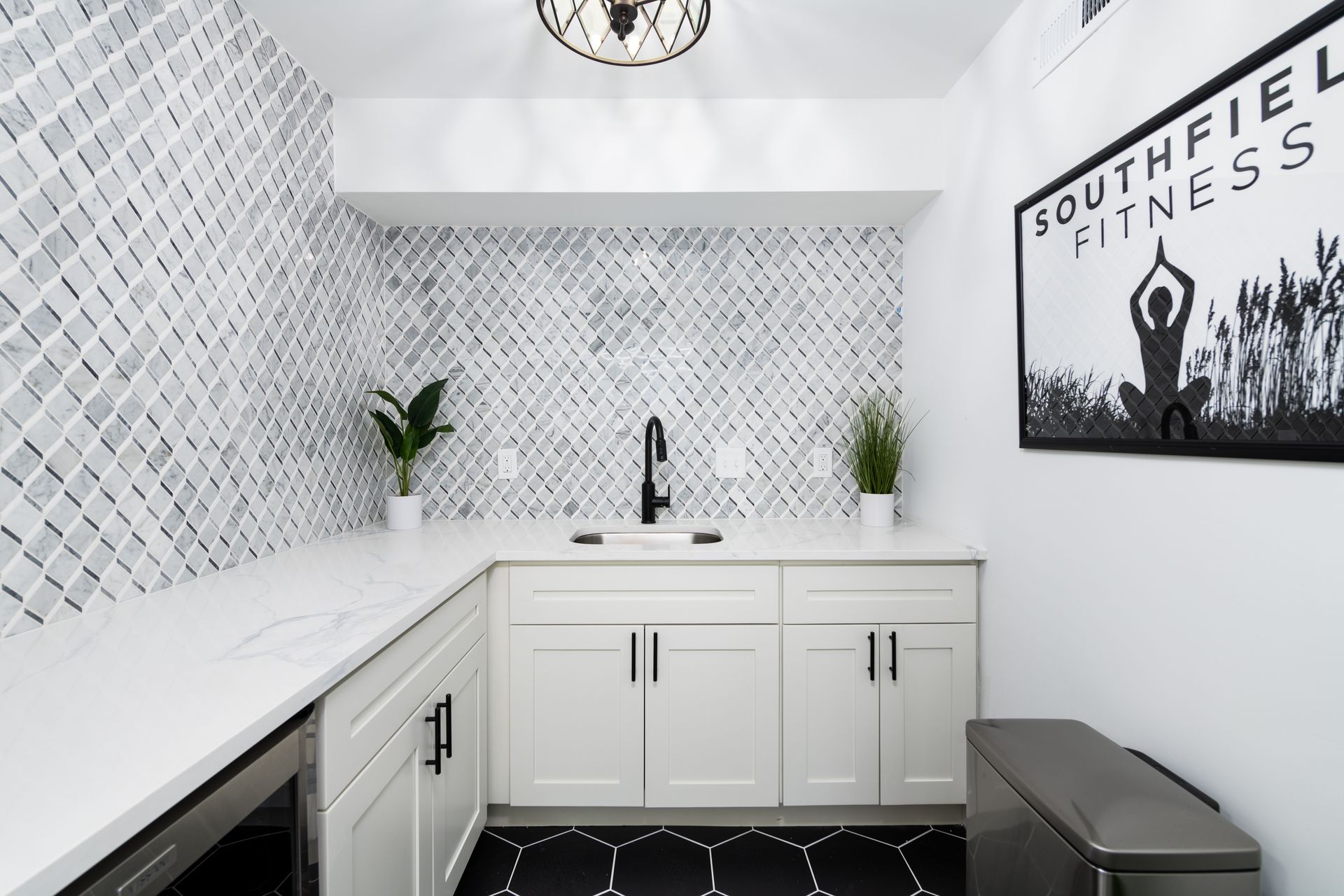 A kitchen with white cabinets and a sign that says southfiel fitness